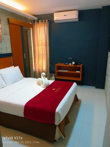 a hotel room with a bed with a towel on it at La Gensol Plaza Hotel in Mamburao