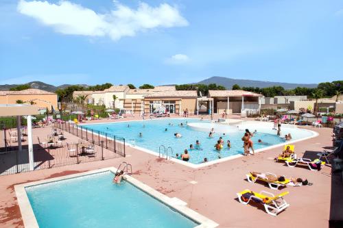 un groupe de personnes dans une piscine d'un complexe hôtelier dans l'établissement Maison charmante à Aubignan avec piscine partagée, à Aubignan