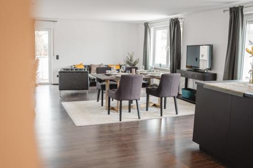 un salon avec une table et des chaises de salle à manger dans l'établissement Smart & Stay Living, à Mörlenbach