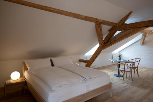 a bedroom with a bed and a table and chairs at FLÜHLI Hotel Kurhaus in Flühli