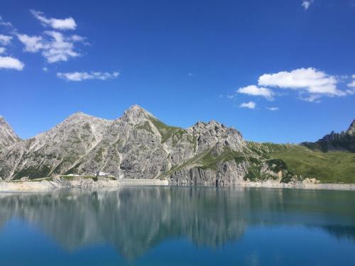 a mountain reflecting in the water of a lake at Apartment Mountainview in Bürs