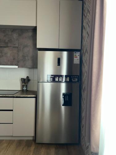 a stainless steel refrigerator in a kitchen with white cabinets at Mestiakhedi in Mestia
