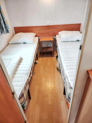 Cette petite chambre comprend 2 lits superposés et une table. dans l'établissement Charmant Bungalow à Saint-Pierre-d'Oléron, à Saint-Pierre-dʼOléron