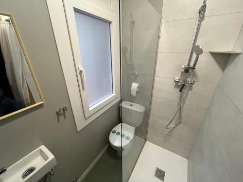 a bathroom with a toilet and a glass shower at Hostal Tarrés in Anglés