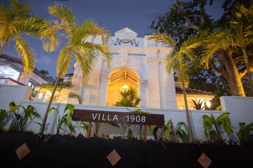 a white building with palm trees in front of it at Villa 1908 in Dodanduwa