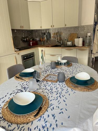 une cuisine avec une table avec des assiettes dessus dans l'établissement Triplex à 200m de la plage - Ô délices marins, à Carnac