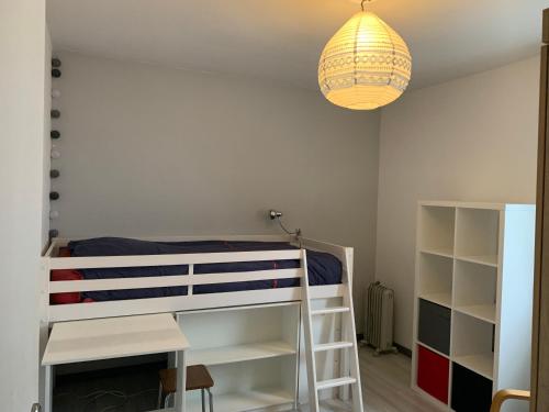 a bedroom with a bunk bed and a chandelier at Appartement calme avec jardin in Bruges