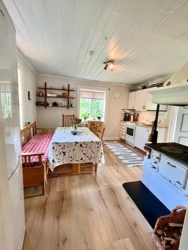 ein Wohnzimmer mit Tisch und Küche in der Unterkunft Stuga i Vallebygden, Axvall in Axvall