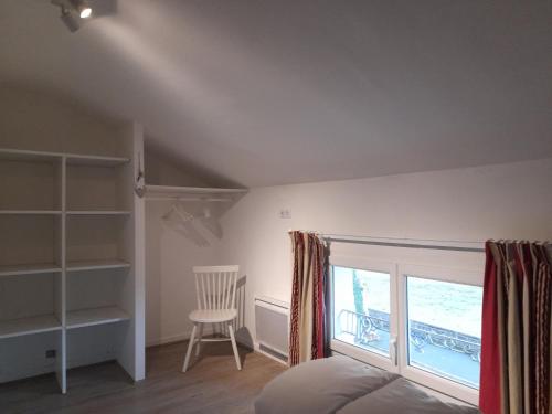 une chambre avec un lit, une fenêtre et une chaise dans l'établissement Daxou, à Dax