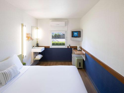 a hotel room with a bed and a sink at ibis Budget Wentworthville in Wentworthville