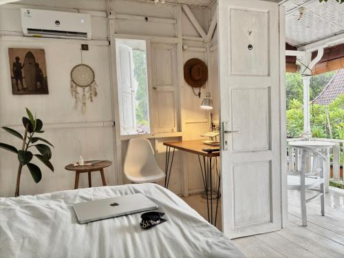 una camera con letto, tavolo e porta di Authentic Bungalow for ocean lovers! a Tanah Lot