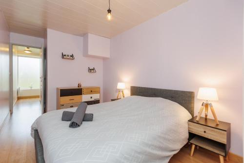 a bedroom with a large white bed and two lamps at LE SOUVENIR D'AILLEURS T2 65m2 in Lhommaizé