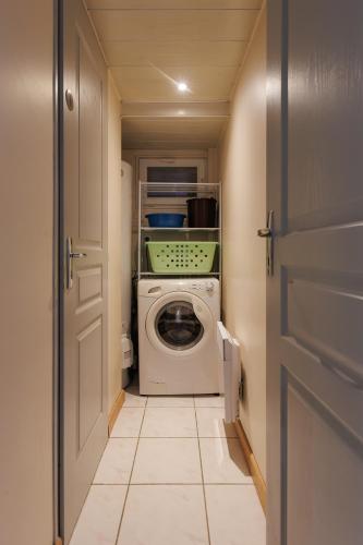 a laundry room with a washing machine and a door at LE SOUVENIR D'AILLEURS T2 65m2 in Lhommaizé