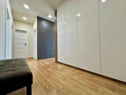 a large room with white cabinets and a wooden floor at Moderný apartmán s terasou in Prievidza