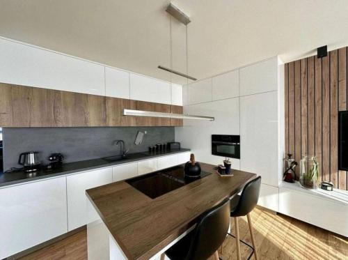 a kitchen with a wooden island in the middle at Moderný apartmán s terasou in Prievidza