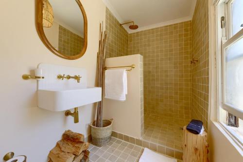 a bathroom with a sink and a mirror at Stoep By Ideas Cartel in Kalk Bay