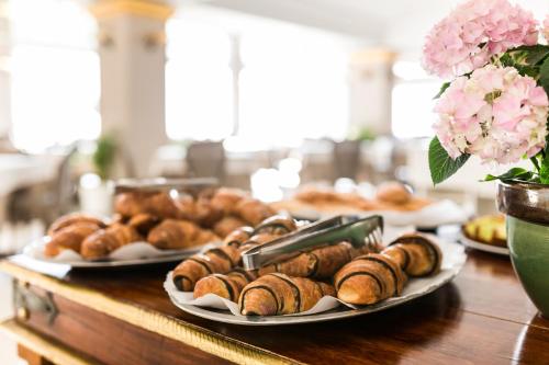 a table topped with plates of pastries on plates at Hotel Kalura in Cefalù