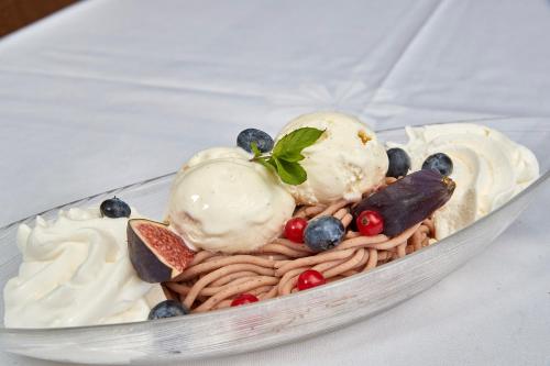 a bowl of pasta with ice cream and berries at Parkhotel Schwert in Weesen