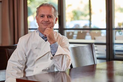 a man sitting at a table wearing a shirt and tie at Parkhotel Schwert in Weesen