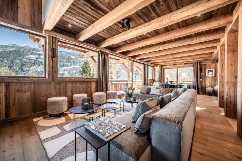 a living room with a couch and tables and windows at Chalet Betula, Saint-Gervais - by EMERALD STAY in Saint-Gervais-les-Bains