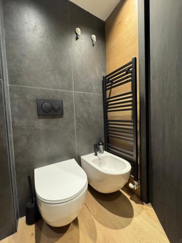 a bathroom with a white toilet and a sink at Suite 1400 in Marilleva