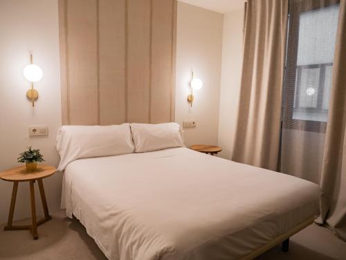 a bedroom with a white bed and a window at Hotel Oriente in Zaragoza