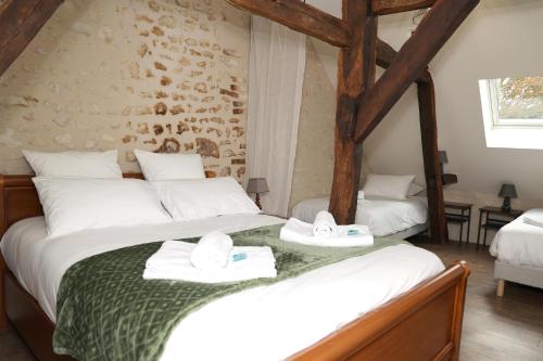 une chambre avec deux lits avec des serviettes dessus dans l'établissement Gite Vergers de Fontenay La Loire, à Lignières-de-Touraine