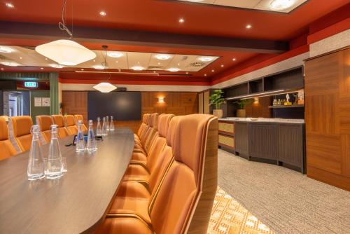 a conference room with a long table and chairs at Fletcher Hotel-Restaurant Klein Zwitserland in Heelsum