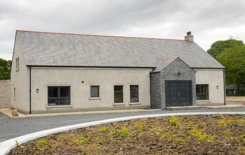 a large white building with a black garage at Tullynore Villa in Hillsborough