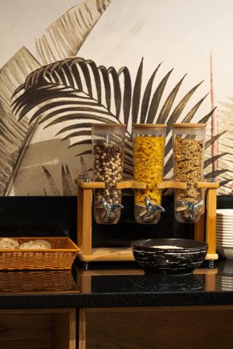 a shelf with four glass jars filled with food at Almaty Hotel in Almaty