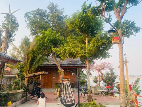 two children playing in front of a house with a playground at Homestay nhà gỗ Lan Anh in Phú Thọ