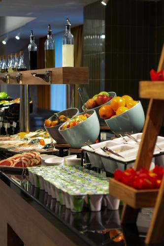 a buffet line with bowls of fruits and vegetables at Almaty Hotel in Almaty