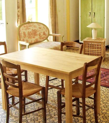 - une table et des chaises en bois dans l'établissement Maison charmante à Ryes avec jardin clos et accès PMR, à Ryes