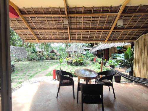 a patio with a table and chairs under awning at Sulu Sunset Beach Resort in Nauhang