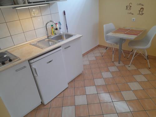 a small kitchen with a sink and a table at Hévíz Erika Apartman in Hévíz