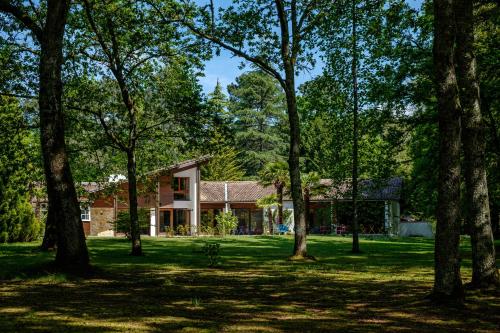 a house in the middle of a yard with trees at Parc de L'Aiguade in Saint-Paul-lès-Dax