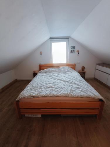 a bedroom with a large bed in a attic at Dom wśród łąk in Suwałki