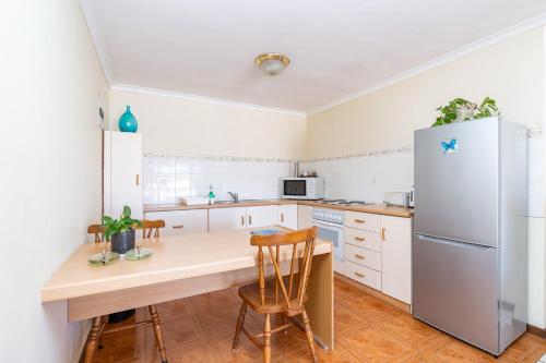 a kitchen with a table and a refrigerator at Montagu Little Sanctuary - Hot Spring Access at Special Rate in Montagu