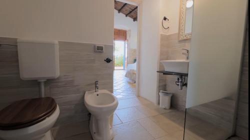a bathroom with a toilet and a sink at Case Brizza in Casale Zappulla