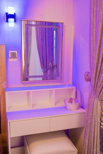 a purple room with a dresser with a mirror at Number Ten by Scarborough - Luxury Serviced Apartments, Asaba in Asaba