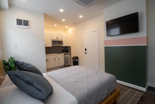 Un dormitorio con una cama y un televisor de pantalla plana. en Diamond Suites Philadelphia Center, en Filadelfia