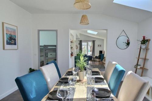 une salle à manger avec une table et des chaises bleues dans l'établissement So Chic Kerfily house with hot tub 8 people, à Loc-Maria-Plouzané