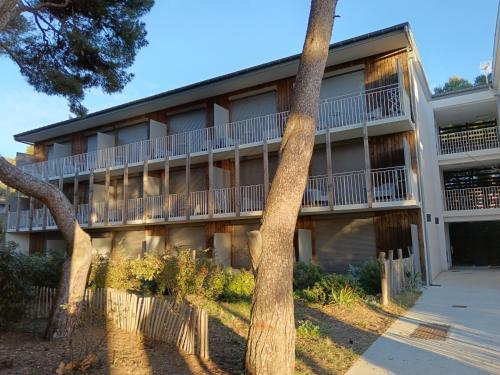 un immeuble d'appartements avec des arbres devant dans l'établissement Domaine du Lazaret - Village vacances 3 étoiles en bord de mer, à Sète