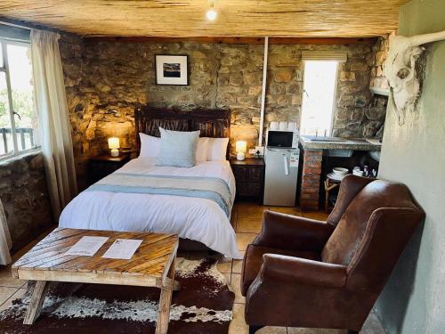 a bedroom with a bed and a chair and a table at Safari Game Camp in Colesberg