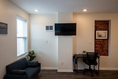 a living room with a couch and a table and a television at Diamond Suites Philadelphia Center in Philadelphia