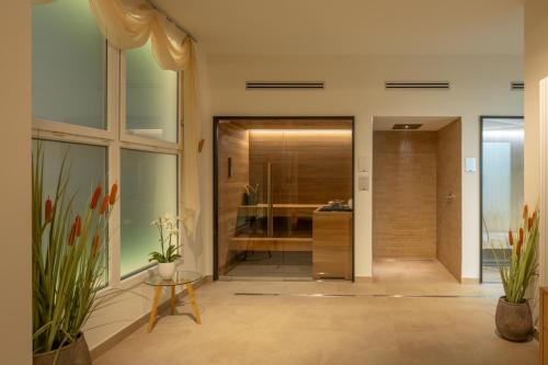 a bathroom with a walk in shower and a glass door at Hotel Caesius Thermae & Spa Resort in Bardolino