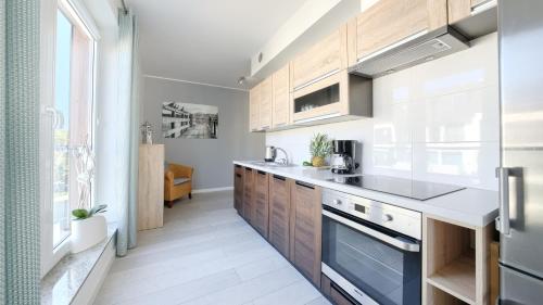 a kitchen with wooden cabinets and a stove at Promenada I, Sun & Snow in Świnoujście
