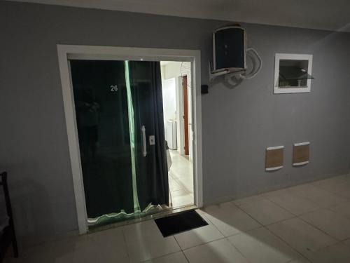 a bathroom with a glass door with a mirror at Suíte Privativa Completa in Cabo Frio