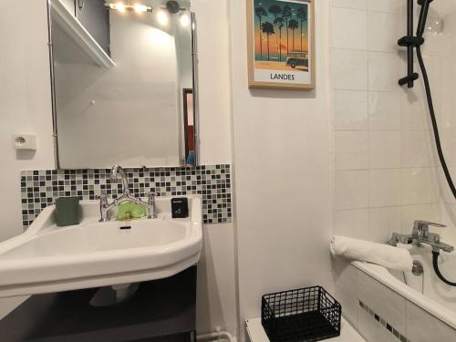 a white bathroom with a sink and a mirror at Studio Cosy AspinIII in Pau