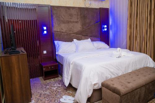 a hotel room with a bed and a television at Number Ten by Scarborough - Luxury Serviced Apartments, Asaba in Asaba